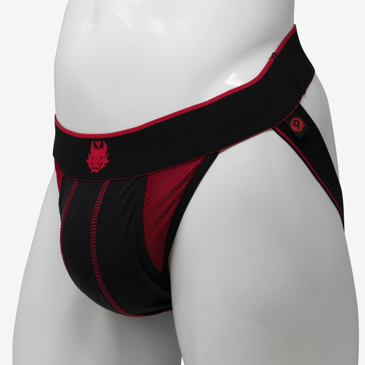 A black and red jockstrap with a prominent red stripe and a small emblem on the front, displayed on a mannequin.